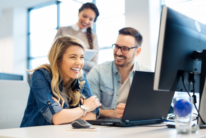 Colleagues looking at information together on a computer.